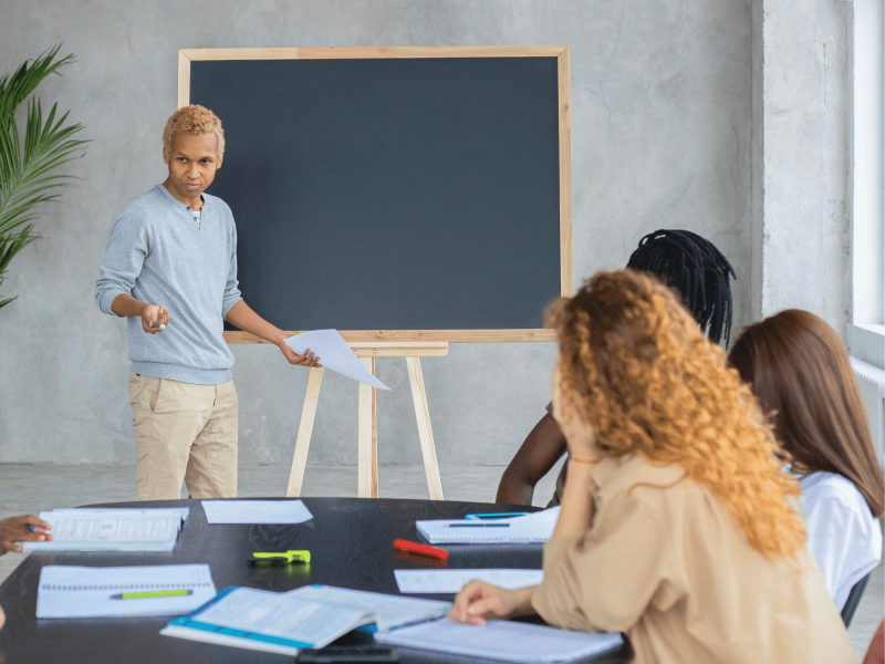 eine Lehrkraft erklärt zum Thema Rassismuskritik vor der Tafel